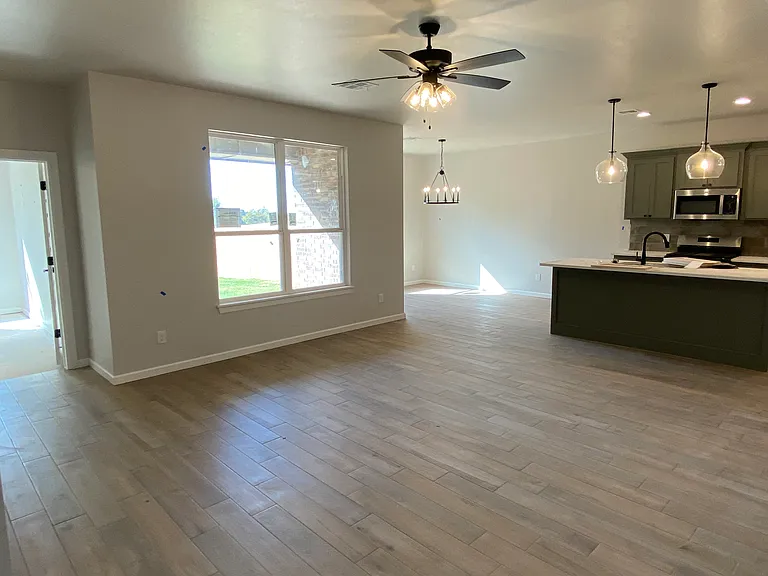 Living Room open to Kitchen and Dining (Primary Bedroom entry on the left)