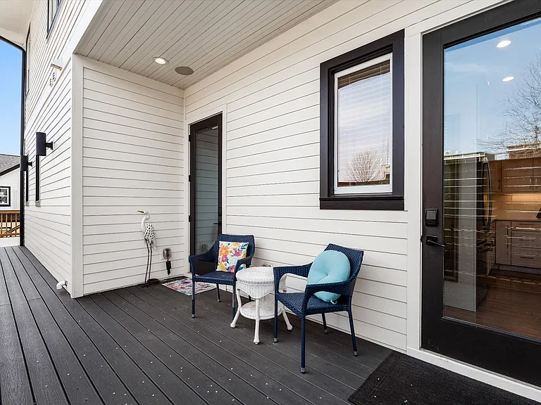 Covered side porch with private entrances to the main home and first-floor ensuite suite.