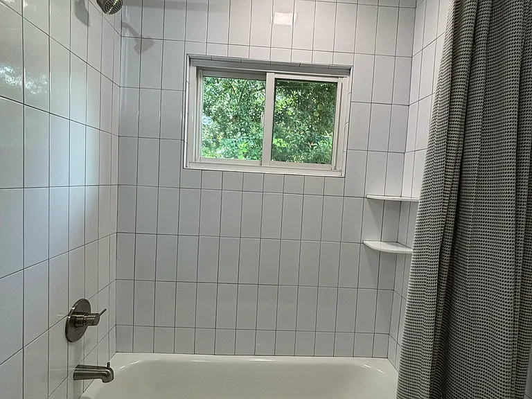 Fully tiled shower surround with tub.
