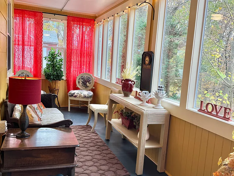 This is another shot of the three season porch. The farmhouse ceiling fan light is yet additional added value to the comfort of this tantalizing bonus space in this furnished apartment rental.