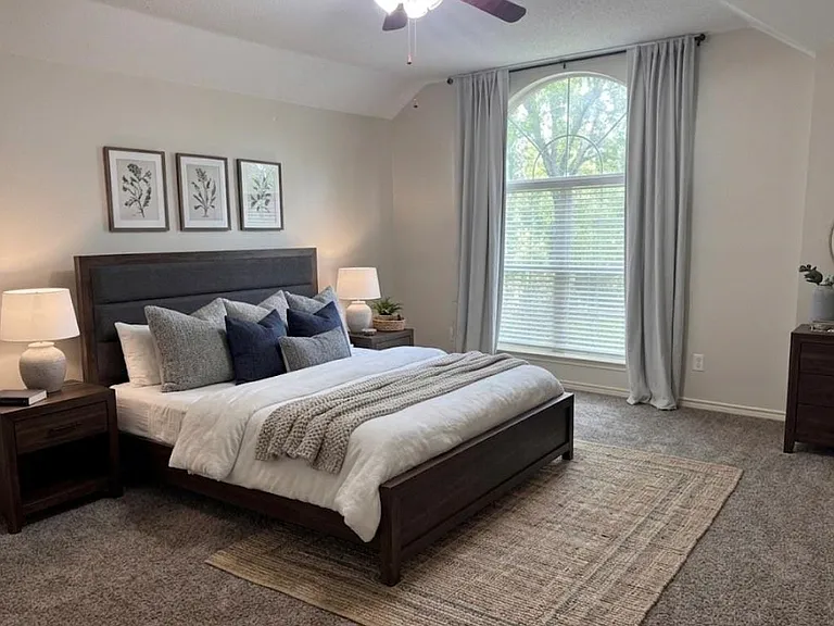 Virtual staging: Carpeted sleeping area featuring a vaulted ceiling with a ceiling fan