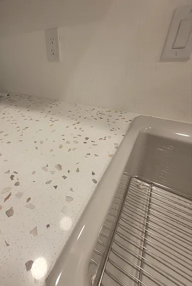 Quartz countertops and cast iron porcelain sink.