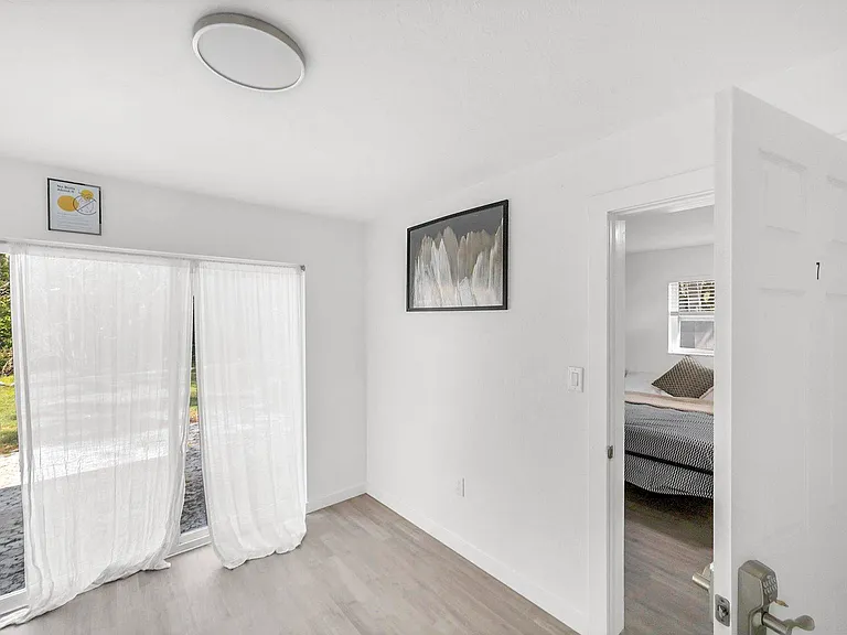 Large area at end of hallway that leads to sliding doors, back parking and back pa