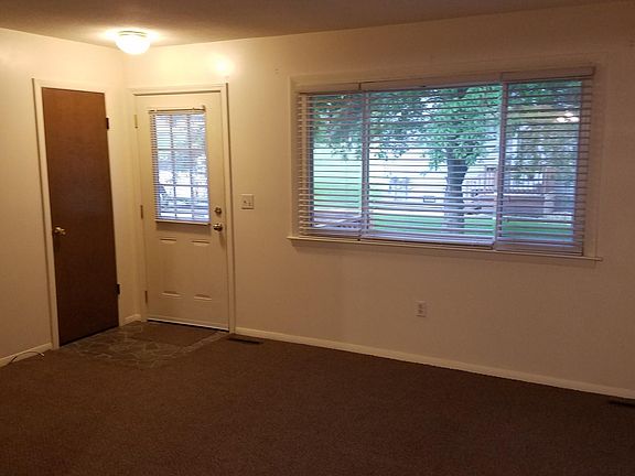 Living room showing blinds and coat closet