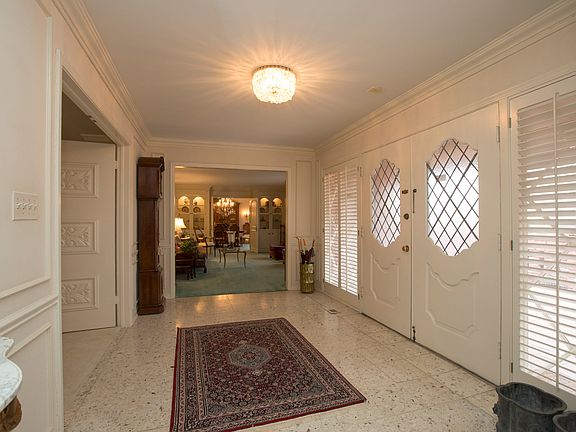 Stunning entry enters into the family room straight ahead and to the living and dining rooms to your right. Notice the beautiful wood carved double doors into the family room.