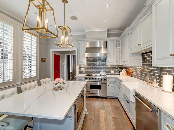 Custom white cabinetry & marble countertops with island seating & lots of light!