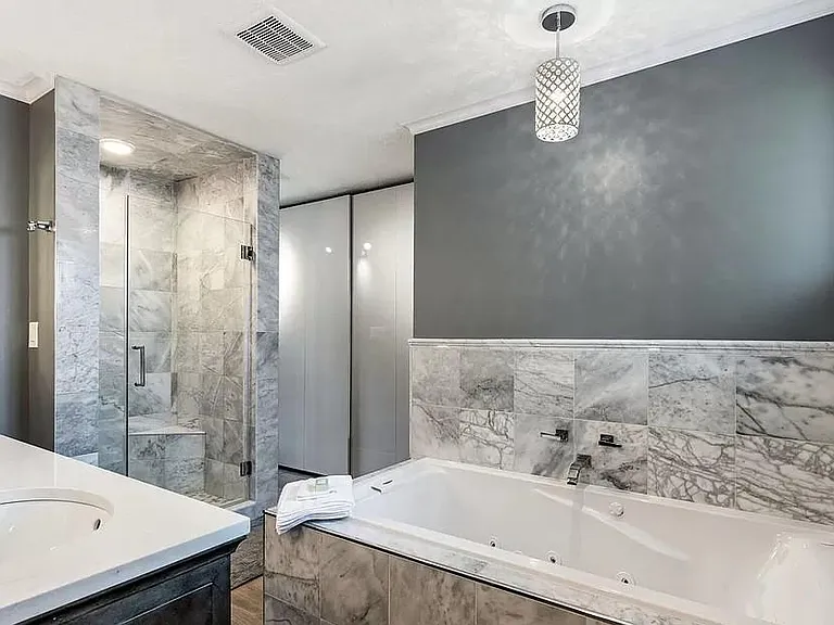 Master bath full tub, beautiful stone counters, contemporary lighting