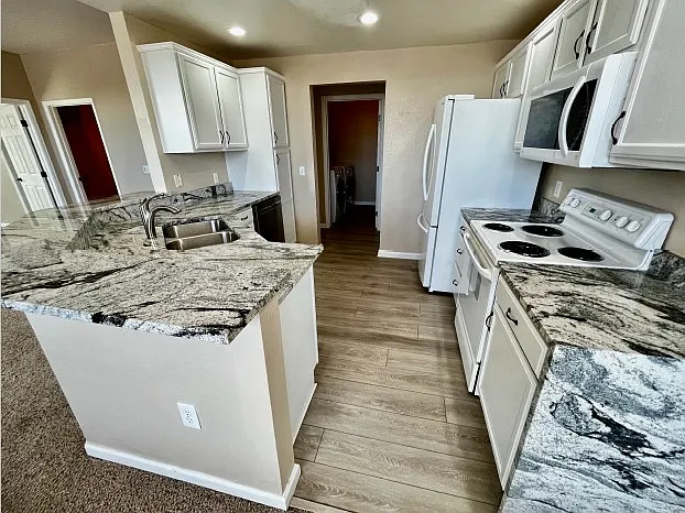 Kitchen view from dining area with view of laundry room.