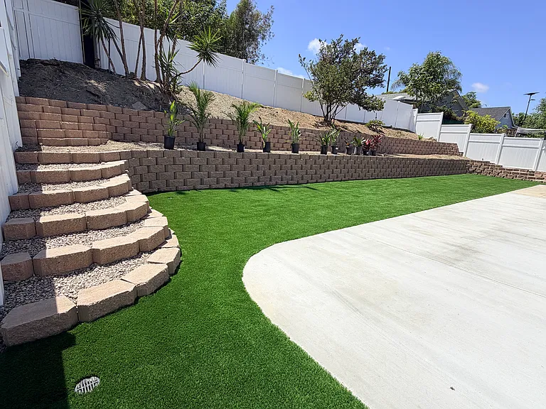 Steps to retraced yard. Large concrete patio wraps around house in backyard.