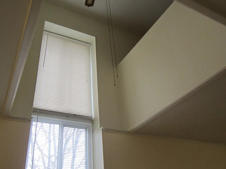 2 story ceiling showing half wall into larger bedroom.
