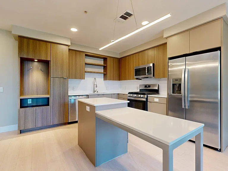 Apartment Kitchen with Quartz counter tops and Wood-Style Flooring.