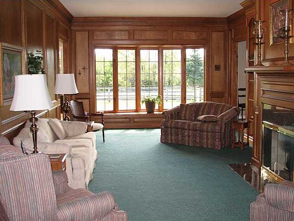 Beautifully paneled family room has built-in bookcases and a handsome fireplace.  Large window overlook the pastures toward the lake.