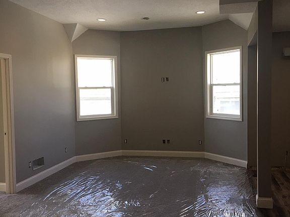 View of living room (new carpet being protected by plastic)