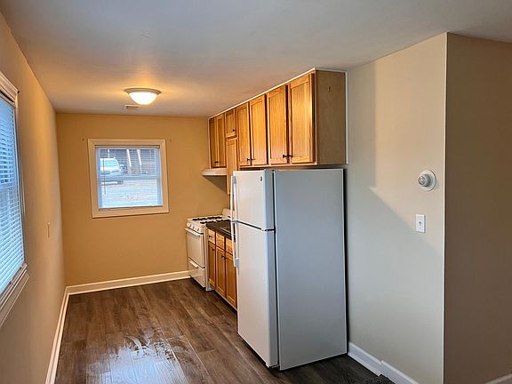 Kitchen with new hickory cabinets, new fridge, and newer flooring.