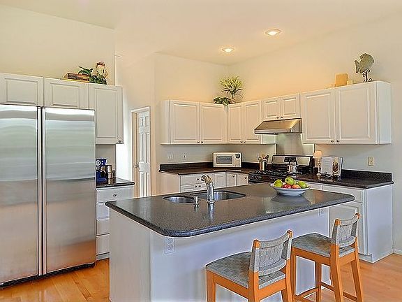 Stainless appliances compliment the white cabinets and corian counters.