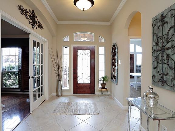 Gorgeous Entry with crown molding, as well as tile that extends into Den