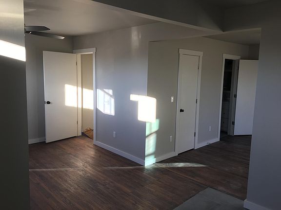 View from the kitchen with living room and entry on the left and bedroom on the the right. The closed door in a walk-in closet a