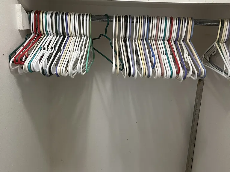 Closets on both sides of hallway leading from kitchen to bath