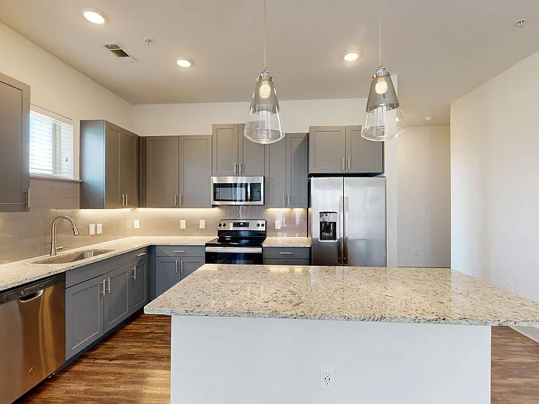 Apartment Kitchen with Granite counter tops and Wood-Style Flooring.