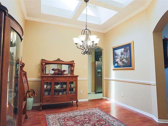 The beautiful skylight aluminates the formal dining room. Notice the crown molding and chair rail for extra flair.