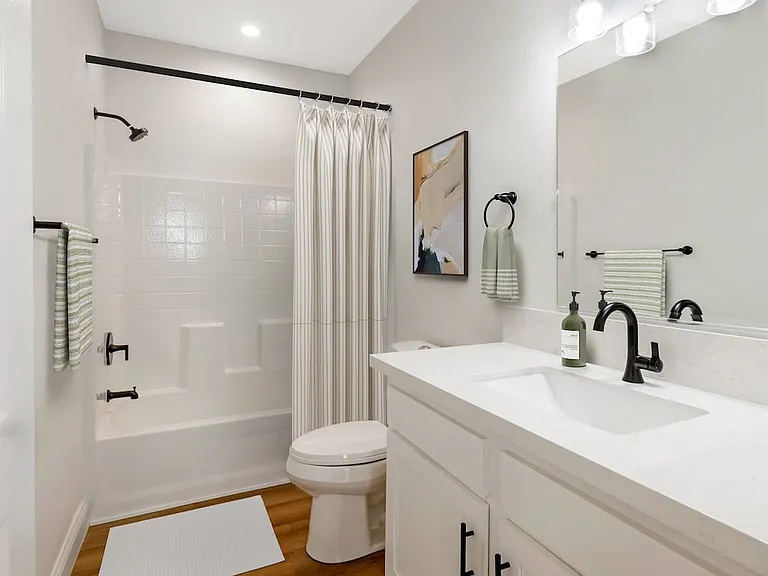 Freestanding Home bath with white cabinetry, white quartz countertops, and hard surface flooring