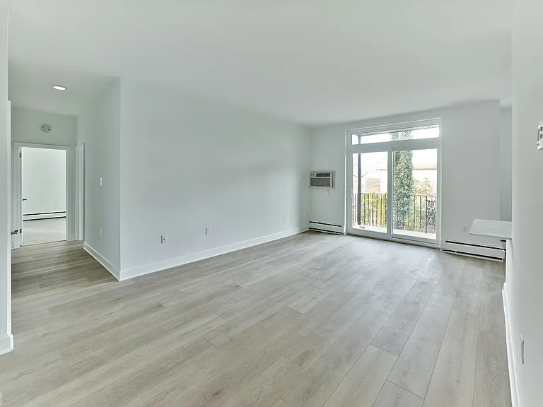 Open and airy living space with large windows and balcony access at Crestwood Apartments in Wayne, PA
