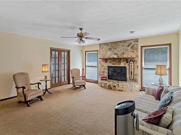 Living room with stone fireplace and gas logs, french door to dining room/study