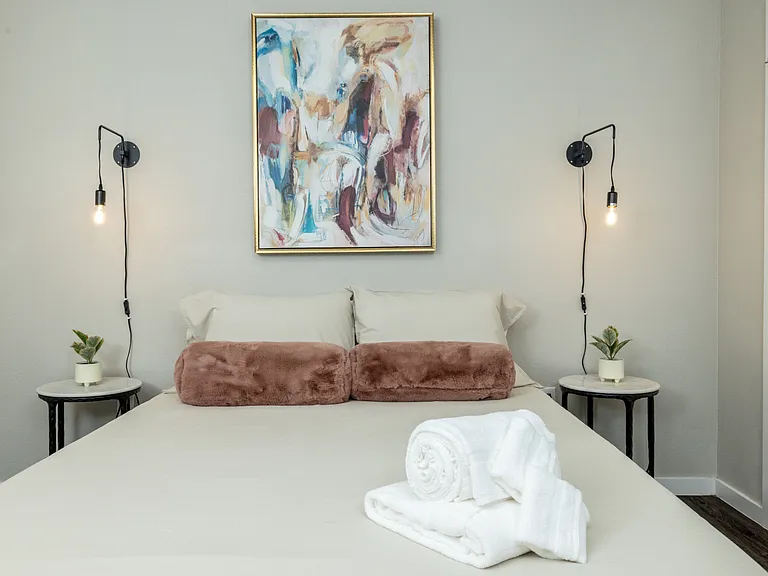 Stylish second bedroom featuring a queen bed and elegant Art Deco pendant lights on each side_designed for comfort with a touch of glamour. This bedroom is located upstairs.