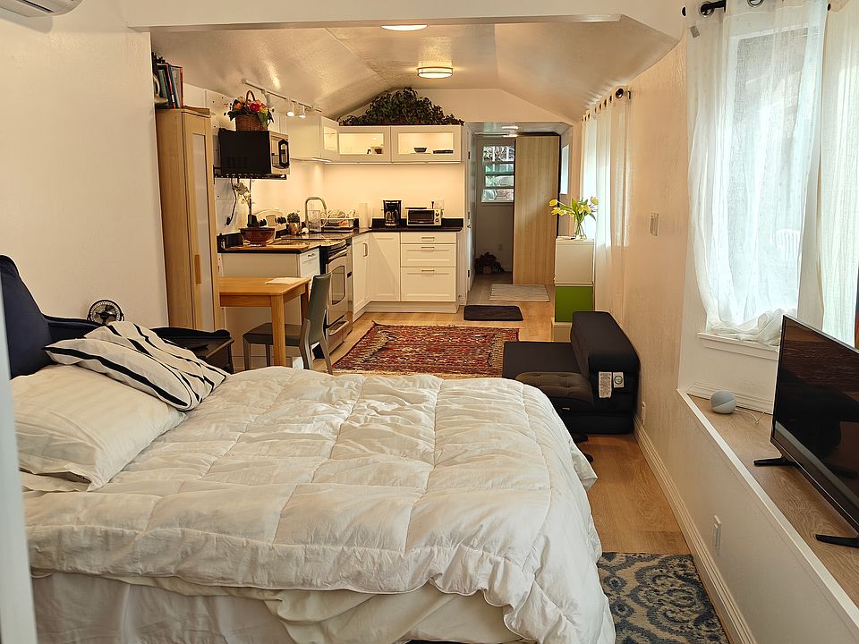 Interior view from front door (full size bed, couch, area carpets and TV for display purposes only and not included in rental)