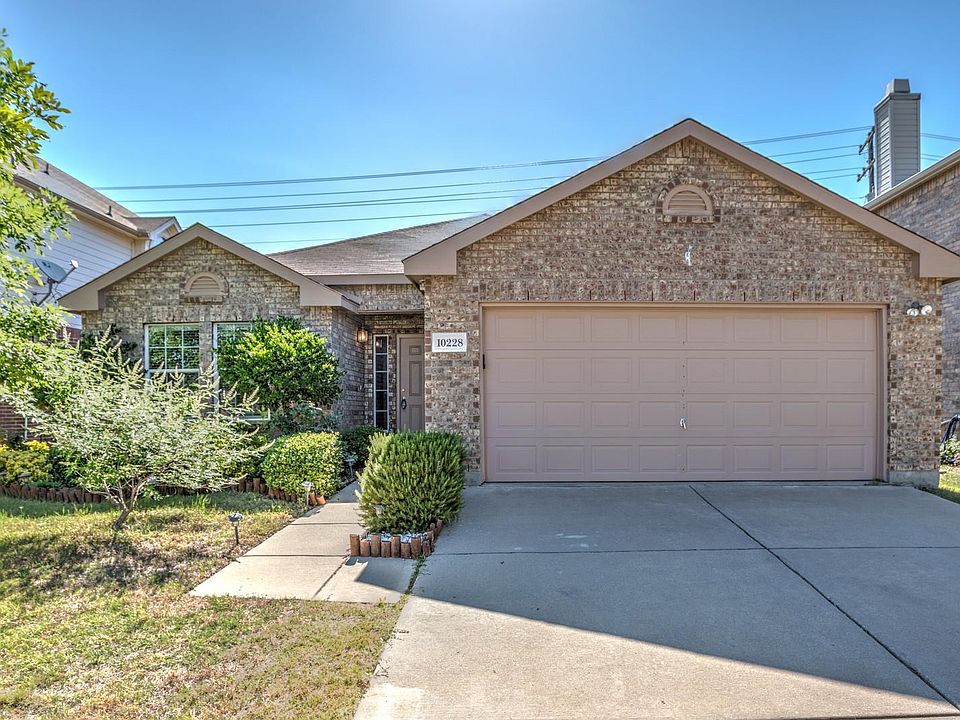 A classic brick elevation welcomes you to 10228 Sourwood Drive.