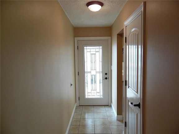 Bright and cheerful ceramic tile foyer (with guest closet) opens to the kitchen and formal living ro