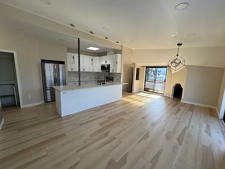 Dining, kitchen, laundry, pantry, and west-facing balcony from living room