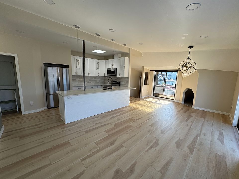 Dining, kitchen, laundry, pantry, and west-facing balcony from living room