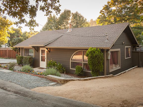 Landscaped front yard with sprinklers along with a second driveway