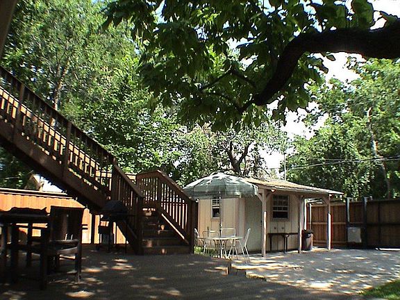 View of the shop with covered porch and car pad when being used for cookouts. Big stairway to upper deck.