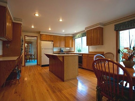 The kitchen has glistening hardwood floors.