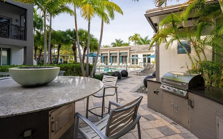 Outdoor lounge at our apartments for rent in Delray Beach, featuring outdoor seating and a grill station.