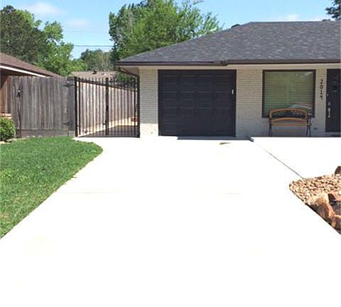 View of the side gate and one car garage which has an automatic opener installed.