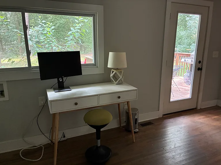 Desk overlooking yard with door leading to large deck.