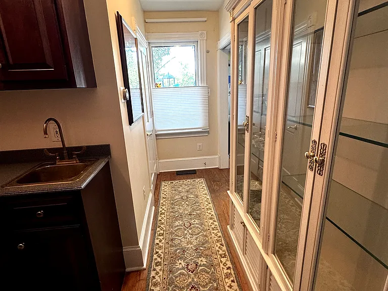 China cabinet and bar area, window on front of house; door on left to bathroom, passage on far left to front door.