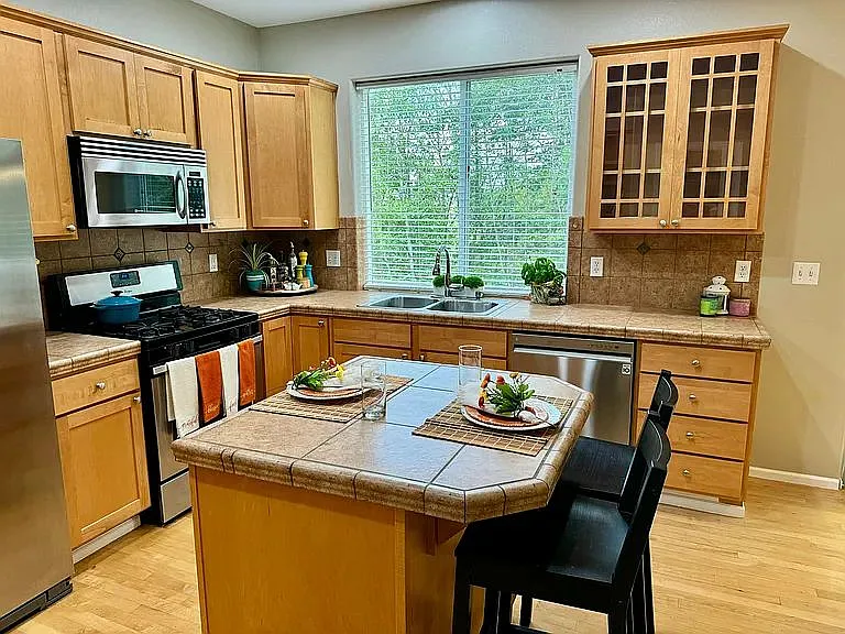 The double sink in the kitchen faces a beautiful private greenbelt