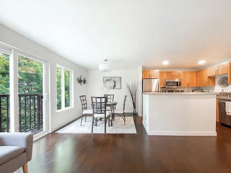 Open concept dining and kitchen area with real hardwood floors and a solid kitchen island- perfect for hosting