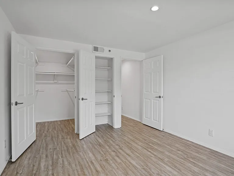 Bedroom with Closet, Built-In Shelving, and Vinyl Flooring