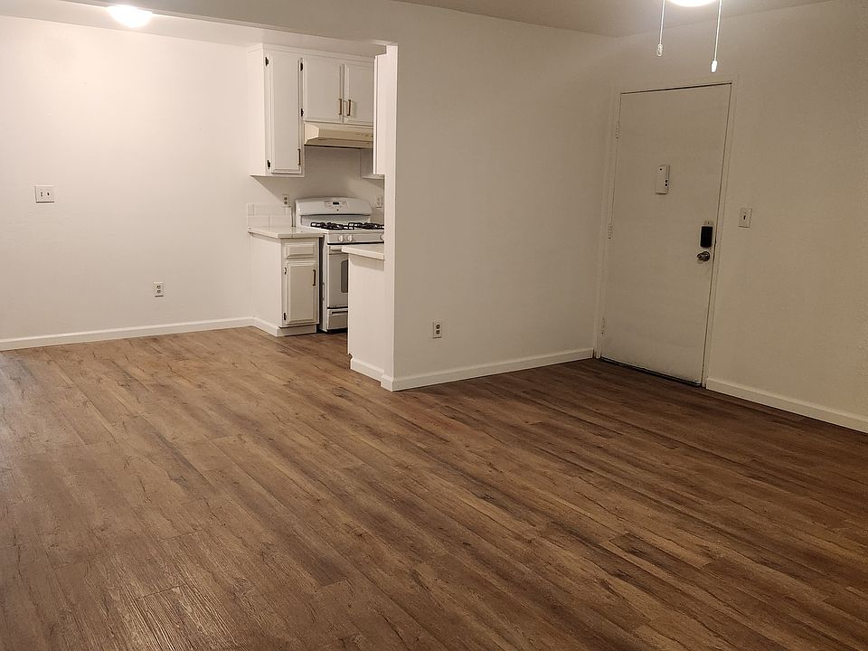 A partial view of the living room looking at the dining area next to the kitchen. Also, there's a small balcony from the other side of the living room.