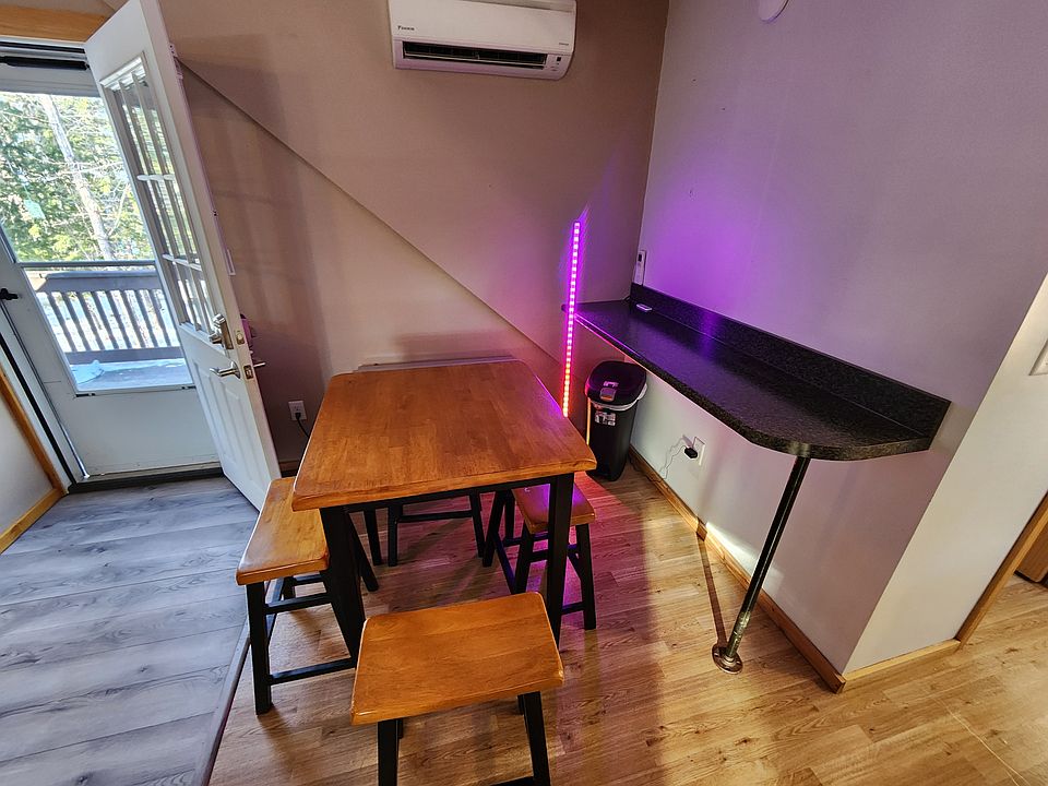Kitchen table and breakfast nook against the wall. Heat pump on the wall with monitor propane heater below that.
