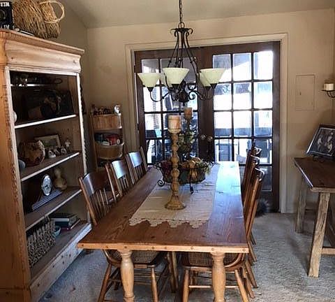 Dining room, located off living room. French doors open to balcony, enclosed in sunroom.