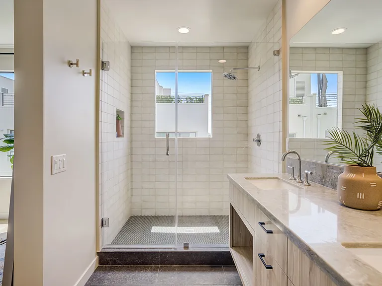 Spacious walk-in shower with a window that provides natural light.