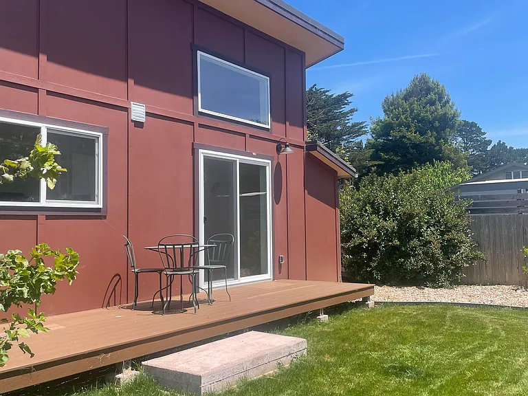The south of home with new lawn area. Bedroom slider is on the right.