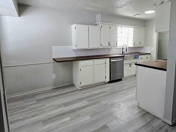 Kitchen with breakfast nook. Butcher block counters, dishwasher, electric stove and garbage disposal.