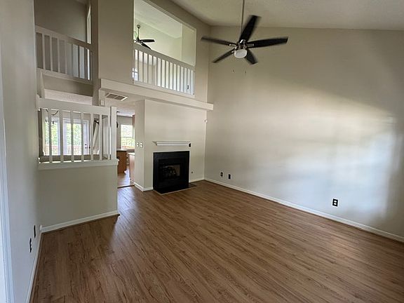 Living room has vaulted ceiling with open loft overlooking it.
